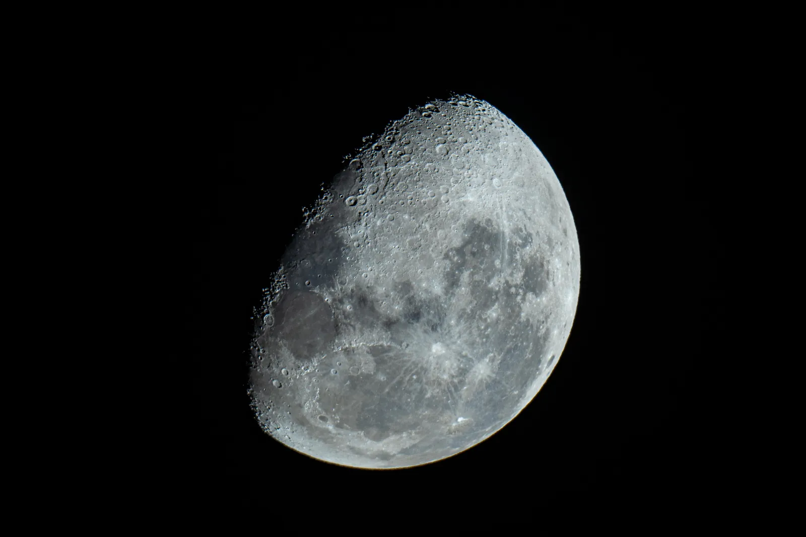 A detailed telescope view of a gibbous moon showing craters and dark lunar seas against a black sky